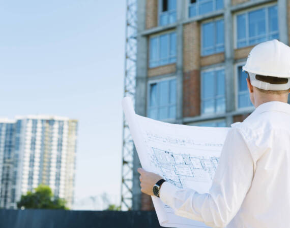 back-view-man-holding-building-plans